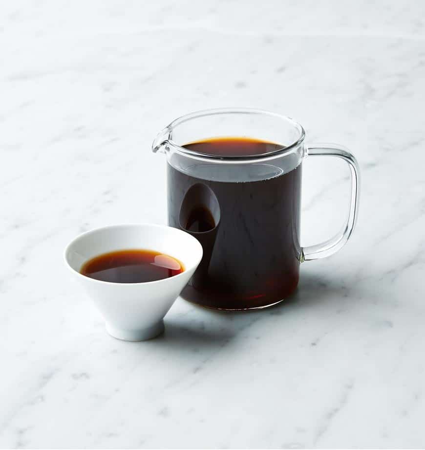 A glass pitcher filled with tea beside a small bowl of tea, labeled Maiden's Ecstasy Tea