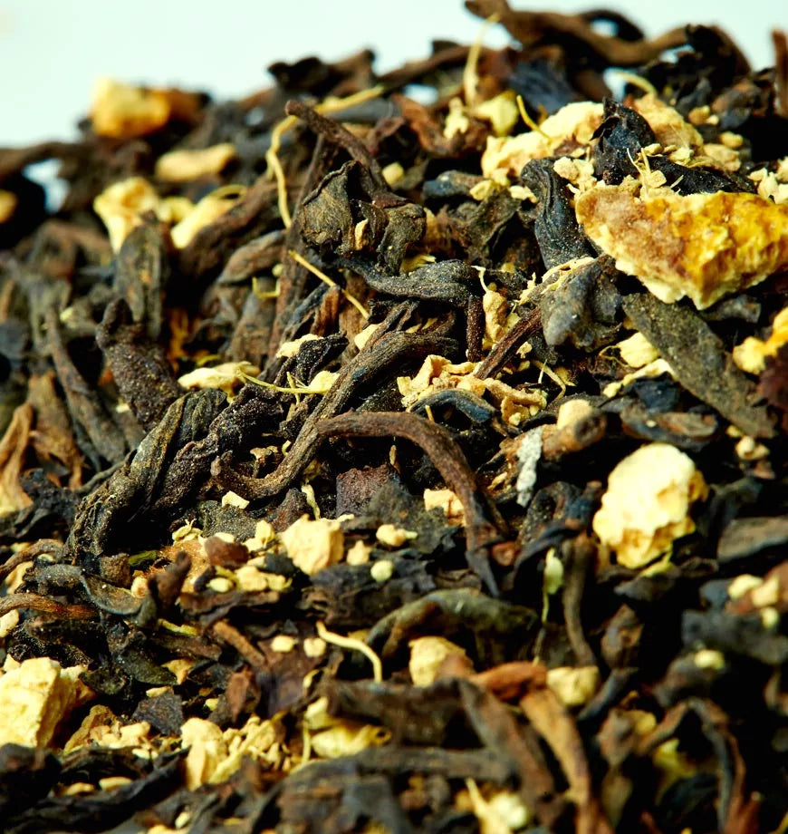 A pile of black tea mixed with dried orange peels, showcasing Blood Orange organic pu erh tea blend.