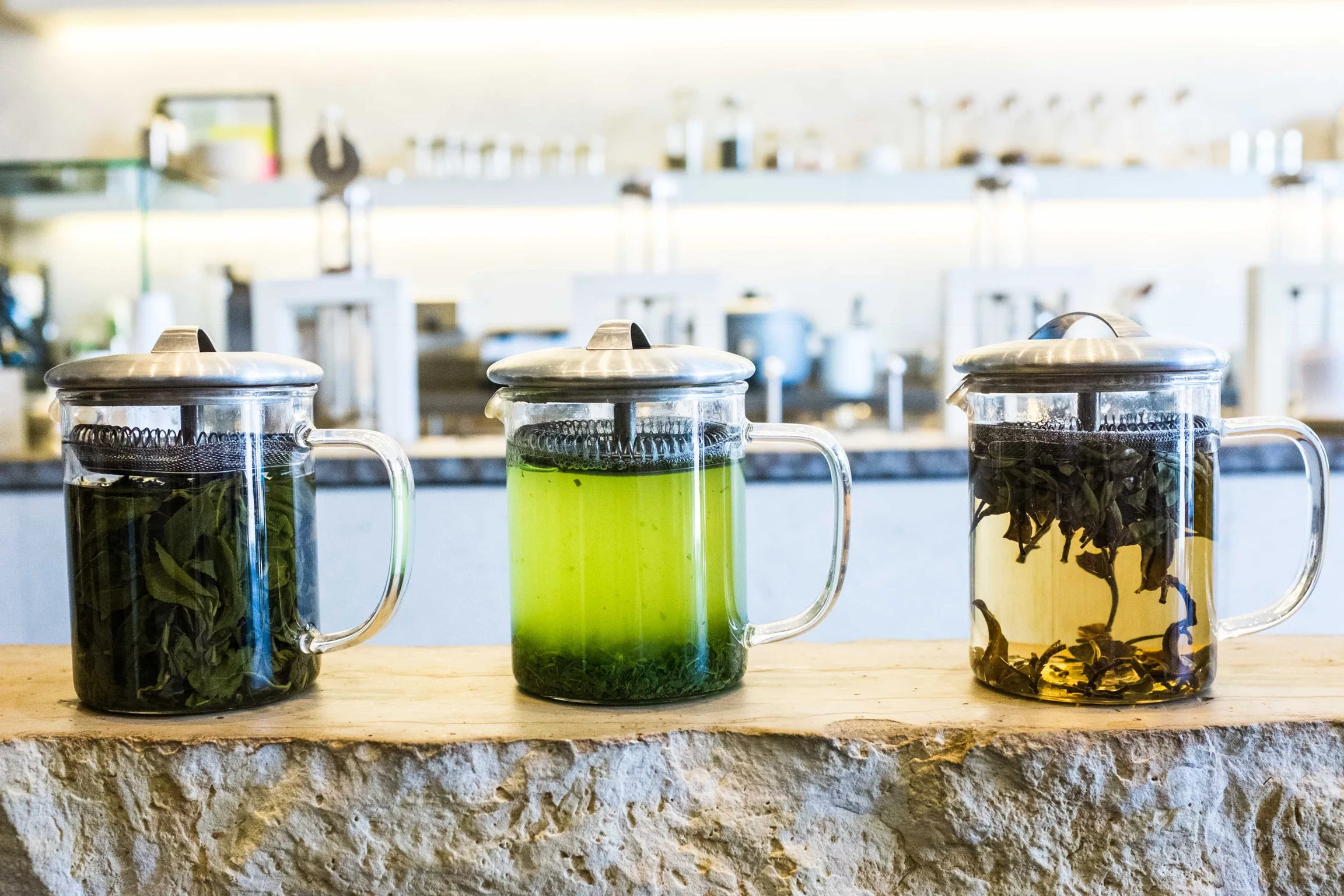 A kitchen counter featuring three varieties of tea, highlighting Green Ecstasy organic green tea.